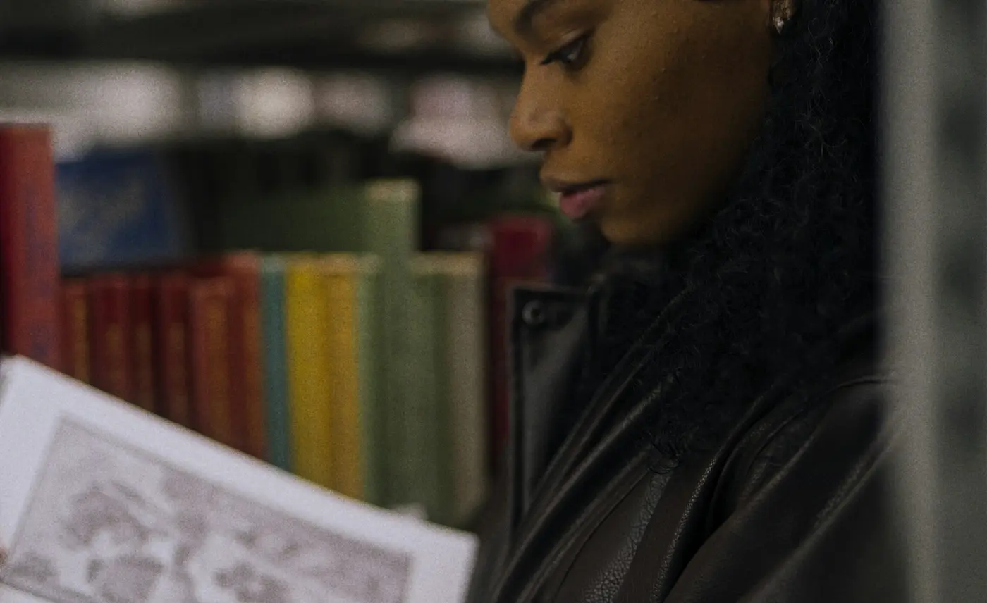 Postgraduate student reading research material in a library